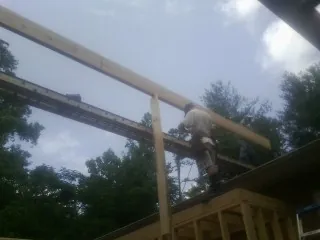 Carpenter setting a ridge beam over a new addition frame — Ice Dam Removal by Roofing Brothers in Maple Grove