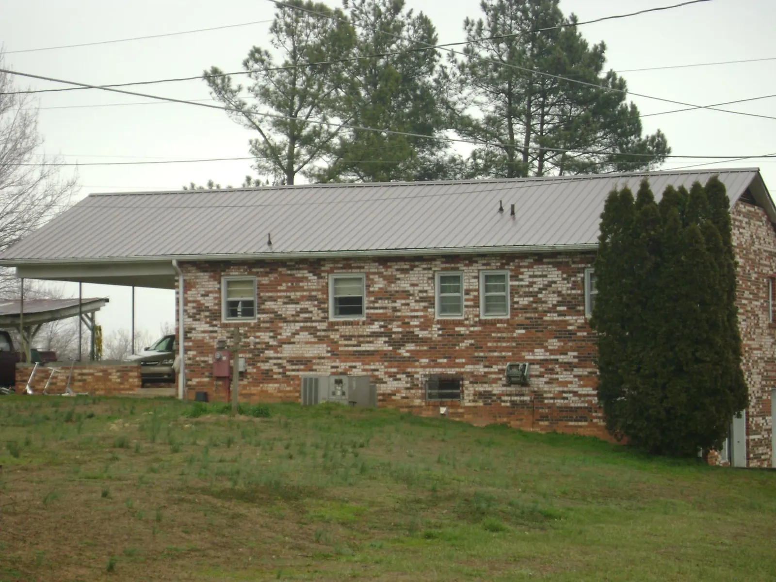 Gray metal roof on a brick split level home with a carport in Maple Grove