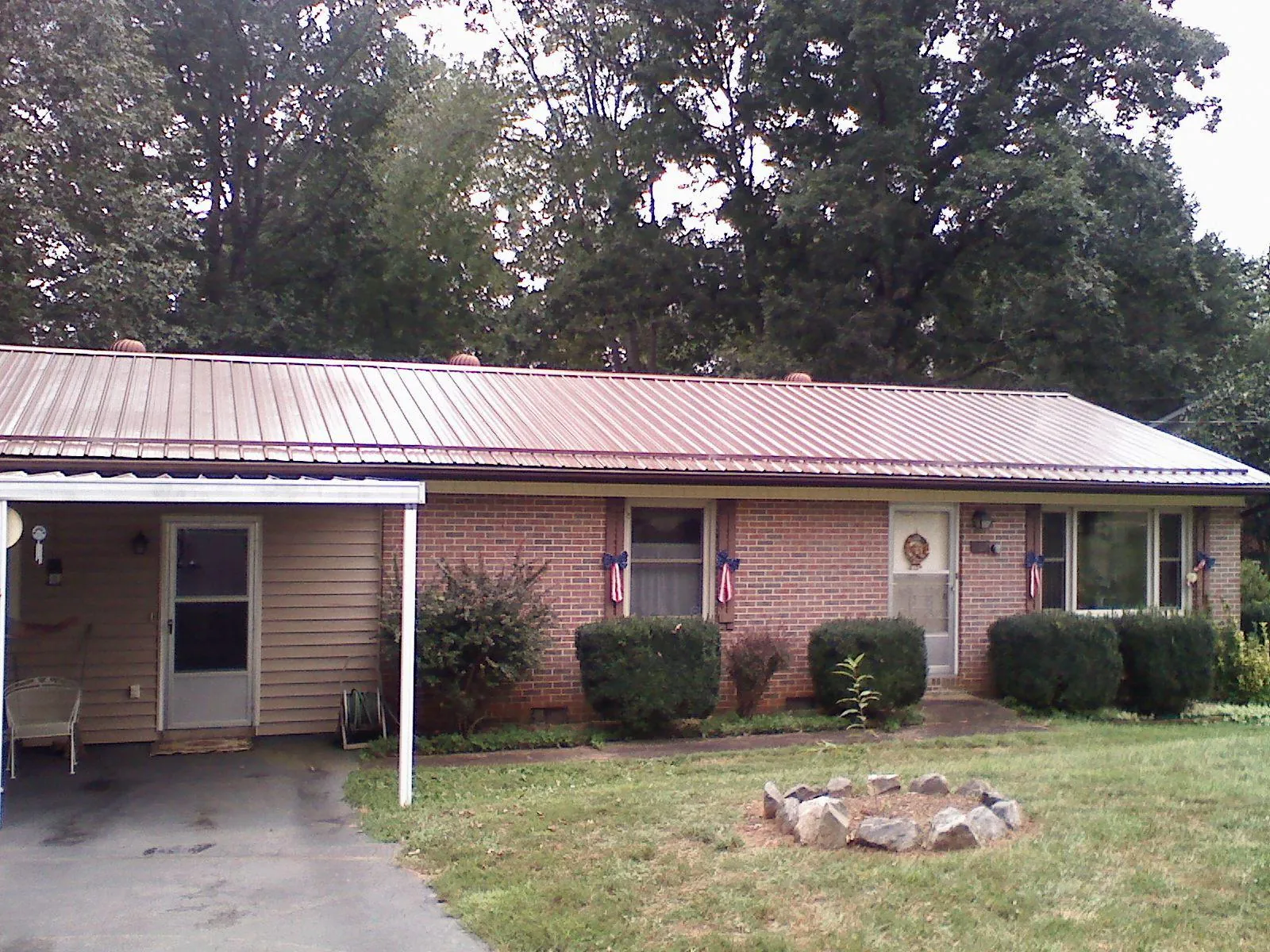 Bronze metal roof and carport on a brick ranch home — Roof Repair work by our crew in Maple Grove
